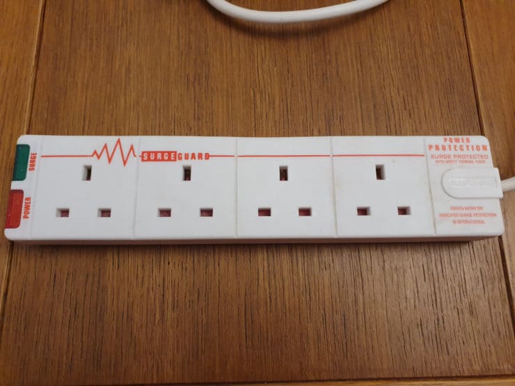 A Masterplug UK surge protected power strip using 'SurgeGuard' protection, on a table.