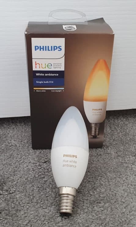 A Philips Hue White Ambiance E14 single bulb box, with the actual bulb outside it (resting against the box).