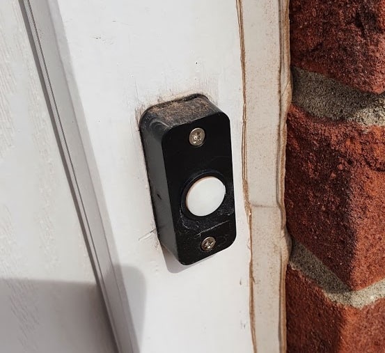 An outdoor traditional doorbell, with the white front cover removed.