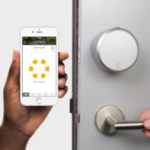 Marketing image showing the August Smart Lock Pro in the background, and a phone app (showing it's unlocked) in the foreground.