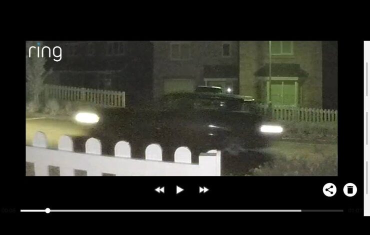 Using 'pinch zoom' in the Ring phone app to try and read information from a passing car at night.