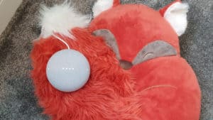 A Google Nest Mini on top of a fox cushion.