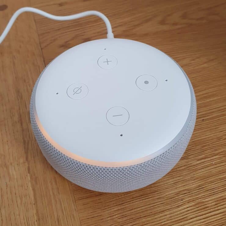 A new Echo Dot (sandstone color) in setup mode with an orange ring going around it.