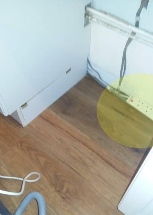 A power strip at floor level in the kitchen