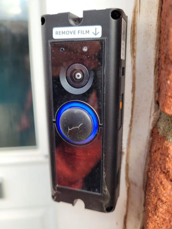 A Ring Doorbell Pro with partially cracked button and faceplate removed