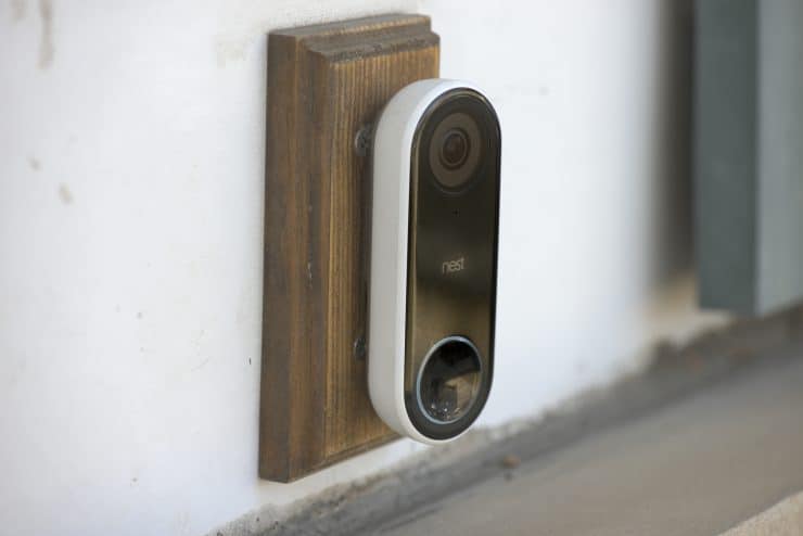 A Google Nest Hello video doorbell mounted on a block of wood